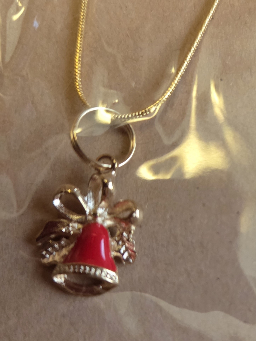 Gold-Tone Red Bell Pendant Necklace with Bow Accent